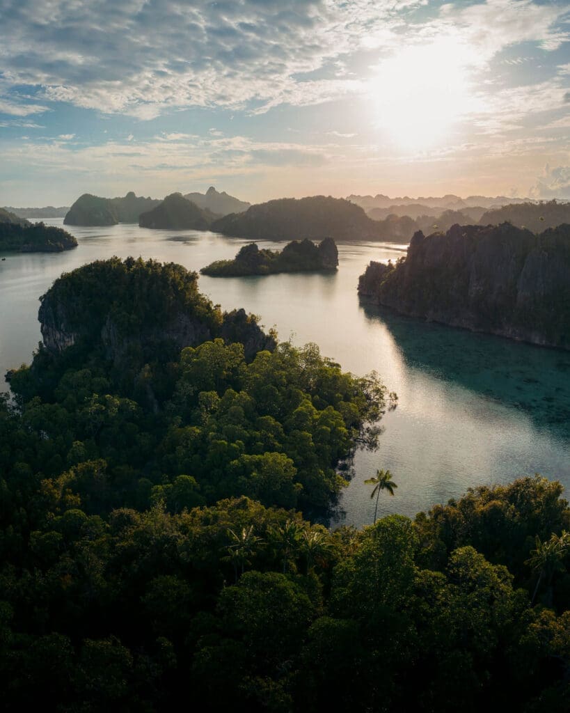 Triton Bay Indonesia drone photo of karst islands, mangroves, and calm sea — luxury liveaboard and yacht charter destination in West Papua.